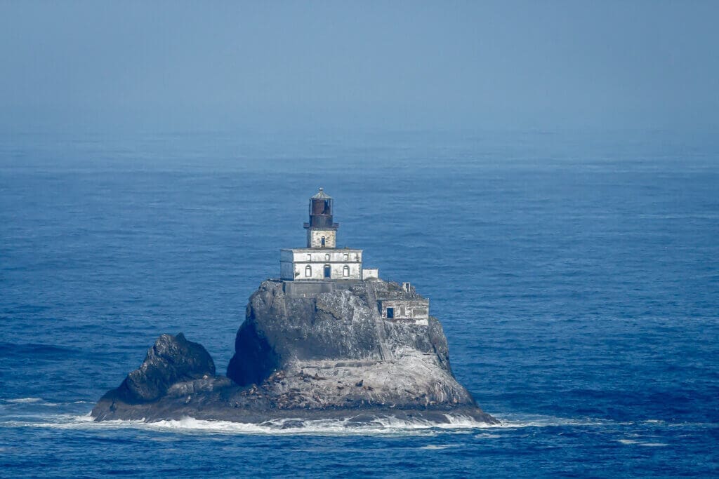 Tillamook lighthouse against a blue ocean with sealions on the r